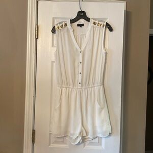 White romper with gold accents. Lined shorts with pockets.